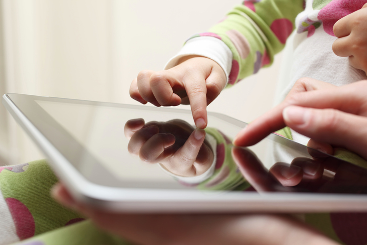 Criança e adulto mexendo num tablet