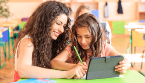professora e aluna na sala de aula, usando um tablet